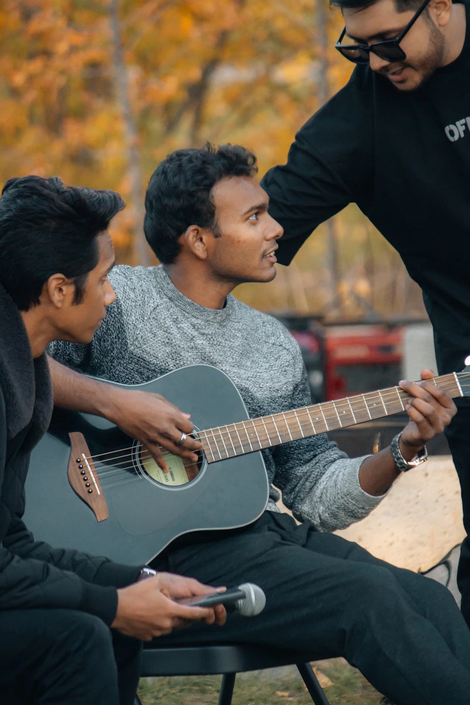 Friends sharing live guitar music at an outdoor BSS gathering
