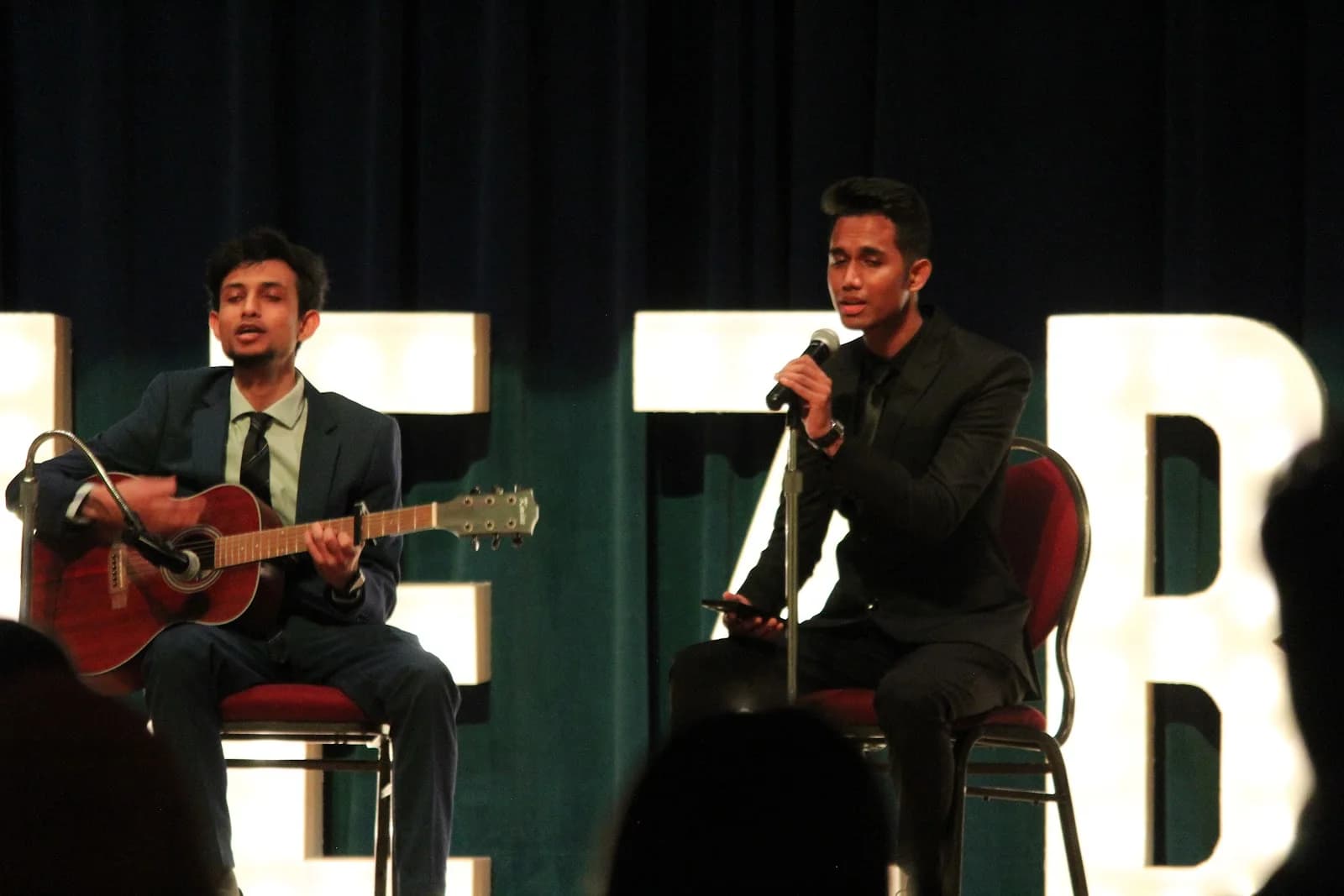 Two performers singing and playing guitar at a BSS event
